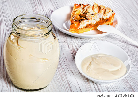 Sour Cream in glass jar with piece of apricot tart 28896338