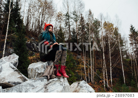 artist girl painting sitting on the rocks at the 28897083