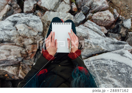 artist girl painting sitting on the rocks at the 28897162