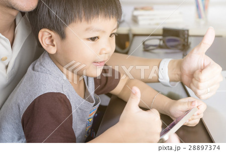 Father and son is using the smart phone technology happily 28897374
