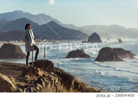 Smiling female situating on coastline 28904460