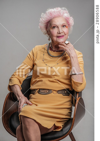 Smiling elderly woman sitting on chair Smiling elderly woman sitting on chair 28906588