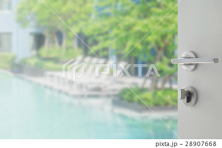 opened door to swimming pool with beach chairs 28907668