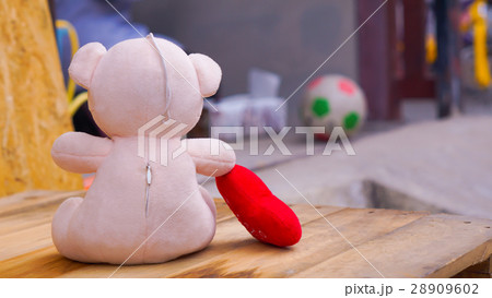 Teddy bear with a heart sitting on the wood Teddy bear with a heart sitting on the wood 28909602