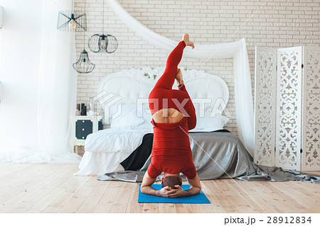 Man makes a stand on his head. 28912834