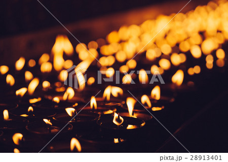 Many candle flames glowing in the dark Many candle flames glowing in the dark 28913401