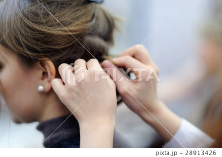 Young woman getting her hair done before party 28913426