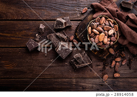 Cocoa beans and chocolate on wooden background Cocoa beans and chocolate on wooden background 28914058