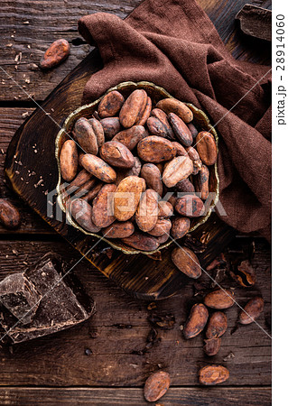 Cocoa beans and chocolate on wooden background Cocoa beans and chocolate on wooden background 28914060