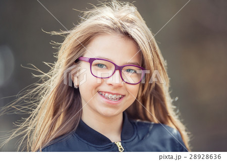 Girl with glasses. Girl with teeth braces. 28928636