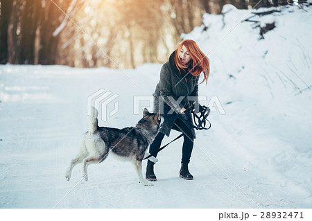 Beautiful girl with dog Husky in snowy woods 28932471