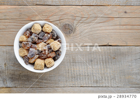 Brown sugar in bowl on wooden table 28934770