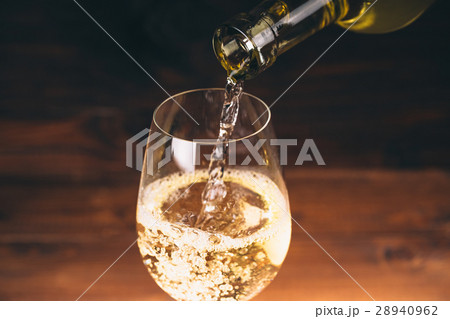 Pouring white wine from a bottle in a close up Pouring white wine from a bottle in a close up 28940962