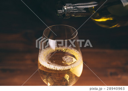 Pouring white wine from a bottle in a close up Pouring white wine from a bottle in a close up 28940963
