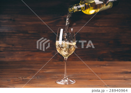 Pouring white wine from a bottle in a close up Pouring white wine from a bottle in a close up 28940964