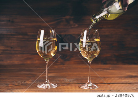 Pouring white wine from a bottle in a close up  28940976