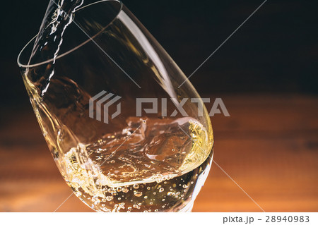Pouring white wine from a bottle in a close up Pouring white wine from a bottle in a close up 28940983
