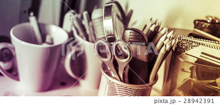 Writing instruments in glasses on a shelf. Writing instruments in glasses on a shelf. 28942391