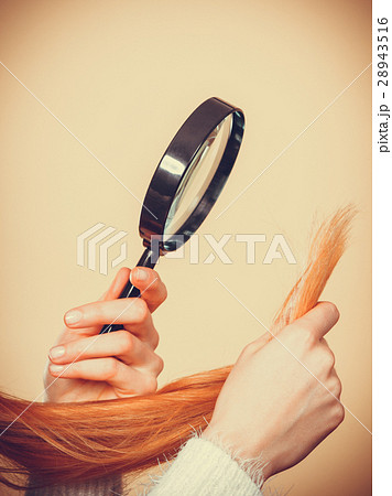 Sad woman looking at damaged hair ends. 28943516