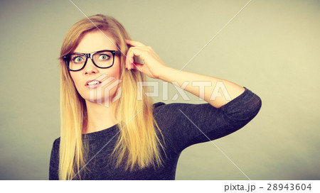 Nerdy woman in eyeglasses being confused Nerdy woman in eyeglasses being confused 28943604