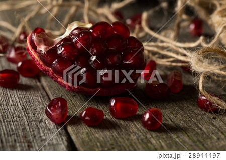 Fresh pomegranate and berries lie on wooden table Fresh pomegranate and berries lie on wooden table 28944497