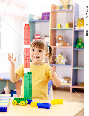 Little girl play with building bricks in preschool Little girl play with building bricks in preschool 28946281