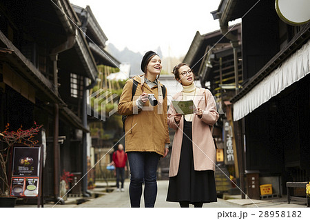 古い町並みを観光する外国人女性と日本人女性 古い町並みを観光する外国人女性と日本人女性 28958182