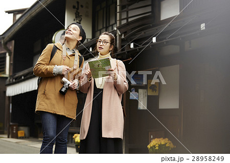 古い町並みを観光する外国人女性と日本人女性 古い町並みを観光する外国人女性と日本人女性 28958249