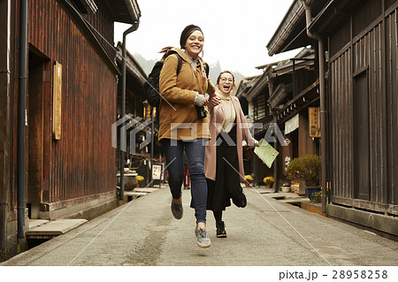 古い町並みを観光する外国人女性と日本人女性 古い町並みを観光する外国人女性と日本人女性 28958258