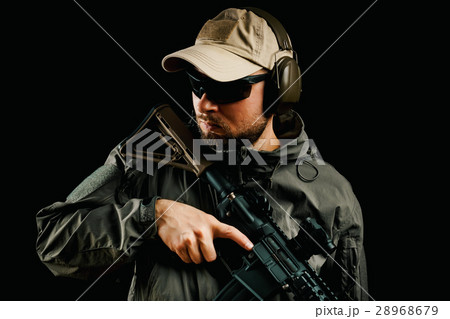 man in cap holding assault rifle 28968679