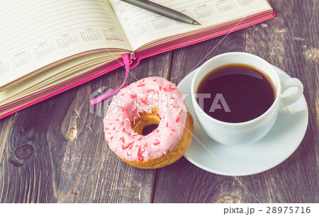 Coffee, donut and notepad on wooden background Coffee, donut and notepad on wooden background 28975716