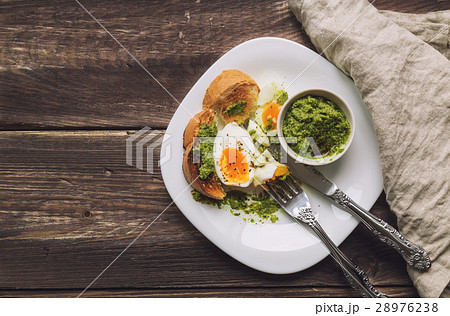 Boiled egg with toasted bread and pesto sauce 28976238