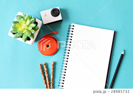 Notebook, camera, accessories on blue background Notebook, camera, accessories on blue background 28985732
