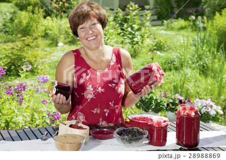 Happy woman with pots of raspberry jam 28988869