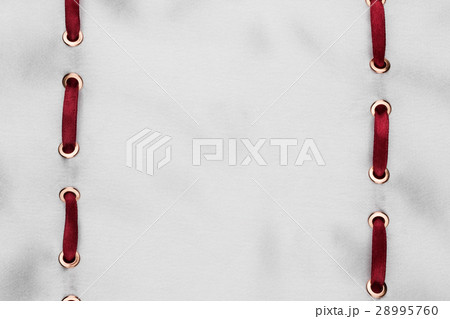 red satin ribbon inserted in white satin fabric 28995760
