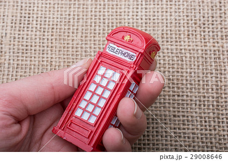 Hand holding a phone booth on a canvas background 29008646