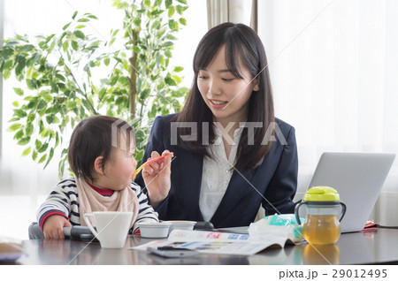 赤ちゃんに離乳食を食べさせるワーキングマザー 赤ちゃんに離乳食を食べさせるワーキングマザー 29012495