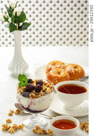 Breakfast of granola, buns , honey and tea . Breakfast of granola, buns , honey and tea . 29012592