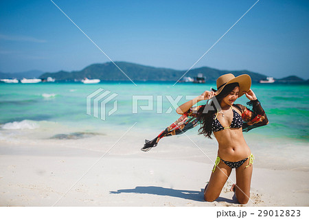 A girl hold a hat and posing at the beach. A girl hold a hat and posing at the beach. 29012823