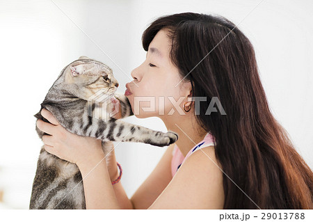 Young woman holding and kissing her lovely cat Young woman holding and kissing her lovely cat 29013788
