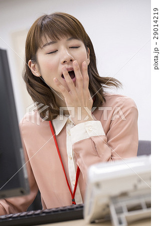 オフィスであくびをする女性の写真素材
