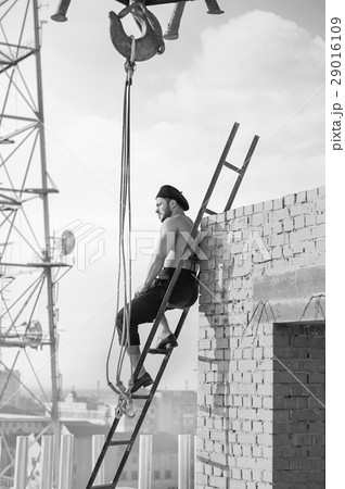 Retro construction worker climbing a ladder while 29016109