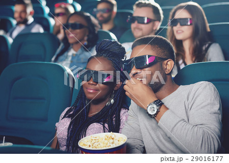 Couple of africans watching film in 3d glasses. Couple of africans watching film in 3d glasses. 29016177