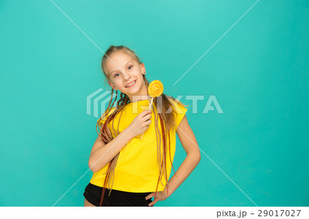 The teen girl with colorful lollipop on a blue 29017027