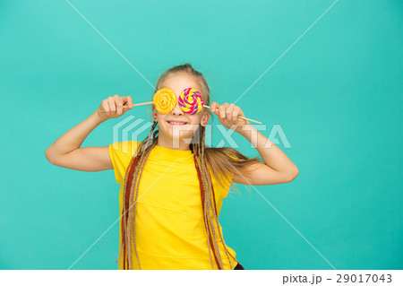 The teen girl with colorful lollipop on a blue The teen girl with colorful lollipop on a blue 29017043
