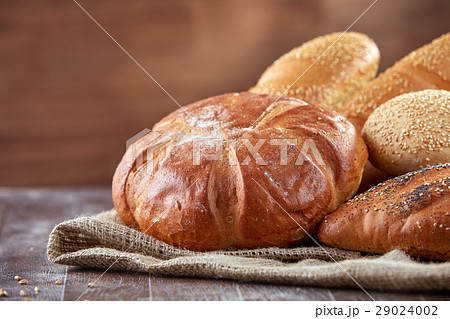 Fresh bread on a cloth linen with brown background 29024002