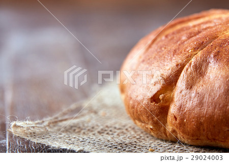 one loaf of bread close-up on a brown background 29024003