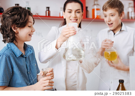 Nice cheerful woman holding a chemical flask Nice cheerful woman holding a chemical flask 29025383