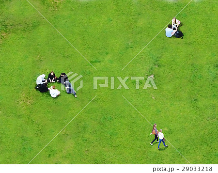 草原でピクニックや散歩しながらくつろぐ若者たちの俯瞰の背景素材イメージのイラスト素材