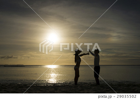 夕暮れのビーチと男女のシルエット 夕暮れのビーチと男女のシルエット 29035502